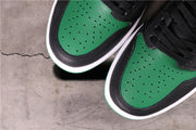 Close-up of the paired sneakers showing perforated green toe boxes framed by black overlays.