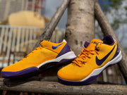 Angled view of a pair of gold Kobe 8 shoes with purple accents