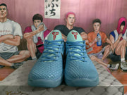 Front view of blue Nike basketball sneakers with matching laces, textured toe boxes, and graphic tongue details.