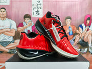Red and black Nike basketball shoes displayed at an angle, showing the side Swoosh and outsole.