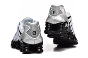 Rear view of the Nike Shox TL sneakers showing silver heel panels and sculpted black soles.