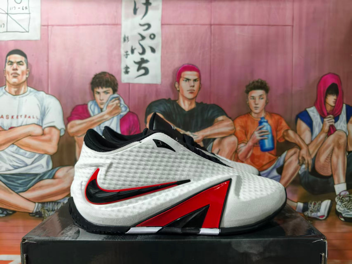 Side view of a white, black, and red Nike basketball shoe on a box.