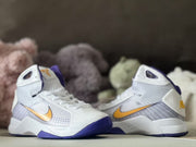 Pair of white kids’ high-top sneakers shown from the front and side with purple soles and gold Swoosh accents.