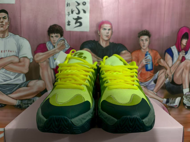 Front view of green and dark green basketball sneakers with bright green laces and textured outsoles.