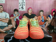Front view of orange-red Nike basketball sneakers with mint-green laces, yellow-beige tongues, and textured uppers.