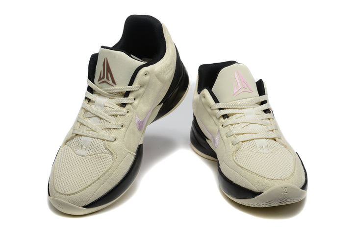 Pair of cream, black and pink Jordan basketball sneakers shown from the front