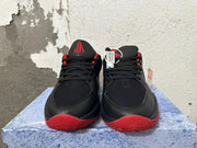 Front view of black and red Nike basketball shoes with black laces and red tongue logo.