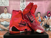 Angled view of red Nike basketball sneakers showing black Swooshes, red laces, patterned knit uppers, and black outsole sections.