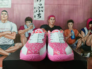 Front view of white and pink basketball sneakers showing white laces, patterned pink lace panels, and pink outsoles.