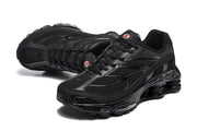 Angled view of a pair of black Nike Shox Ride 2 sneakers with lace-up fronts and visible sole columns.