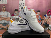 Angled view of the white and purple basketball sneakers, showing the lace-up front, side branding, and gold heel details.