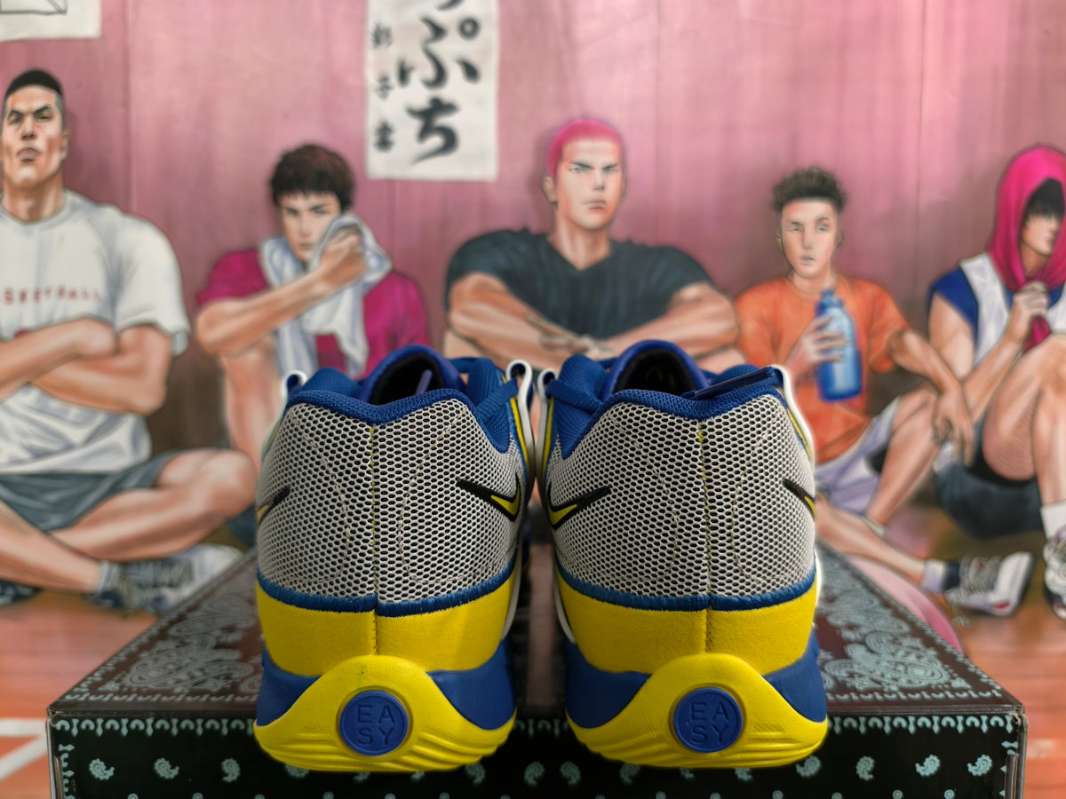 Rear view of royal blue and yellow Nike basketball-style sneakers showing gray mesh heel panels and blue-yellow soles.