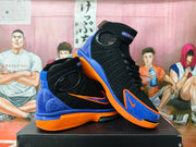 Angled view of black high-top Nike Air Huarache 2K4 shoes with blue and orange panels and ankle straps