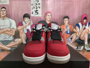 Front view of red and black high-top sneakers with black laces, gray eyelet details, and white soles.