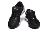 Pair of black and white Nike sneakers shown from the front with lace-up closures and contrasting white midsoles.