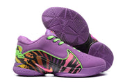 Basketball sneakers displayed with the purple rubber outsoles facing upward, showing geometric tread patterns.