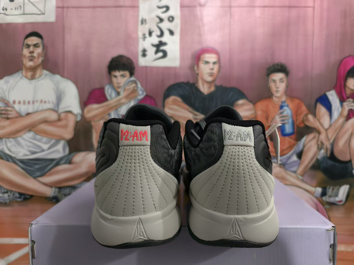 Rear view of gray Nike sneakers showing padded heel panels, black collars, light midsoles, and “12-AM” heel branding.