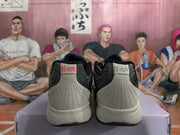 Rear view of gray Nike sneakers showing padded heel panels, black collars, light midsoles, and “12-AM” heel branding.