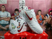 Angled view of white Nike basketball sneakers showing the side Swoosh, illustrated graphics, textured upper, and outsole pattern.