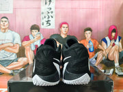 Rear view of black basketball shoes with white logos and white textured outsoles