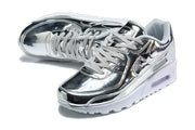 Top angled view of silver Nike Air Max 90 sneakers with gray laces and black accents.