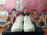 Front view of off-white Nike basketball sneakers with white laces and textured uppers.