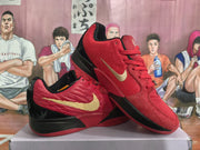 Angled view of paired red, black, and gold Nike basketball sneakers displaying the side Swoosh and heel design.