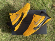 Angled overhead view of both yellow and black basketball shoes.