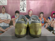 Rear view of gold-toned Nike basketball shoes showing padded gray collars, textured panels and dark translucent outsoles.