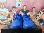 Front view of a pair of blue basketball sneakers showing the lace-up closure and perforated toe panels.