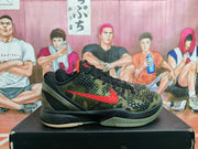 Side view of green and black camouflage Nike basketball-style sneaker with red Swoosh detailing on a shoebox.