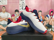 Pair of white, navy, red, and gold Nike basketball shoes shown from the side