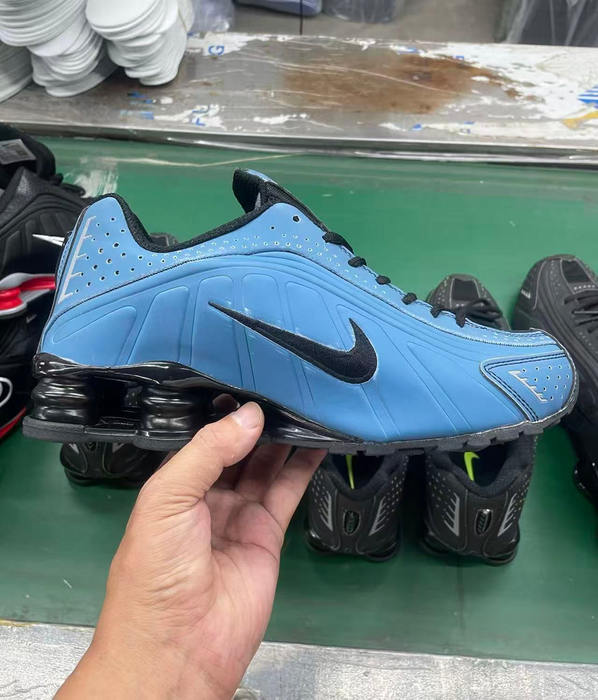 Side view of a blue Nike low-top sneaker with black Swoosh, laces and heel cushioning columns.
