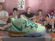 Side view of a mint green and blue Nike basketball sneaker showing the textured upper, layered lace guard, and gray outsole.