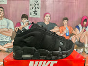 Side profile of a black Nike sneaker showing layered overlays, mesh-like panels, tonal details, and a chunky segmented sole.
