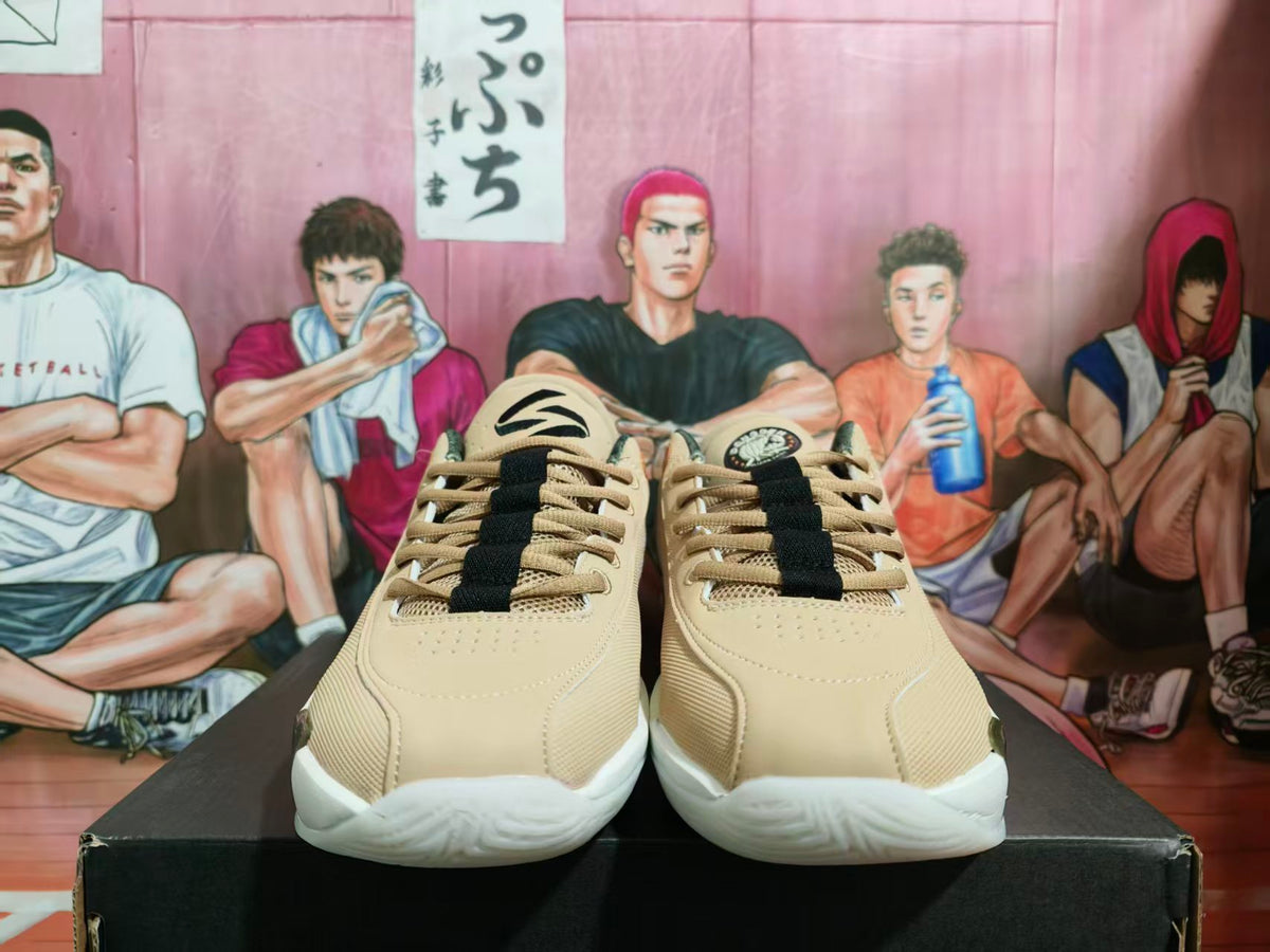Front view of beige Jordan basketball sneakers with black laces and white textured outsoles on a black box.