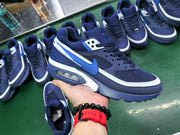 Navy blue Nike sneakers with bright blue swooshes, white trim and visible heel air units, shown among other pairs.