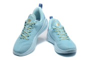 Blue Curry sneakers shown from the front and side, highlighting the laces, padded collars, and textured uppers.