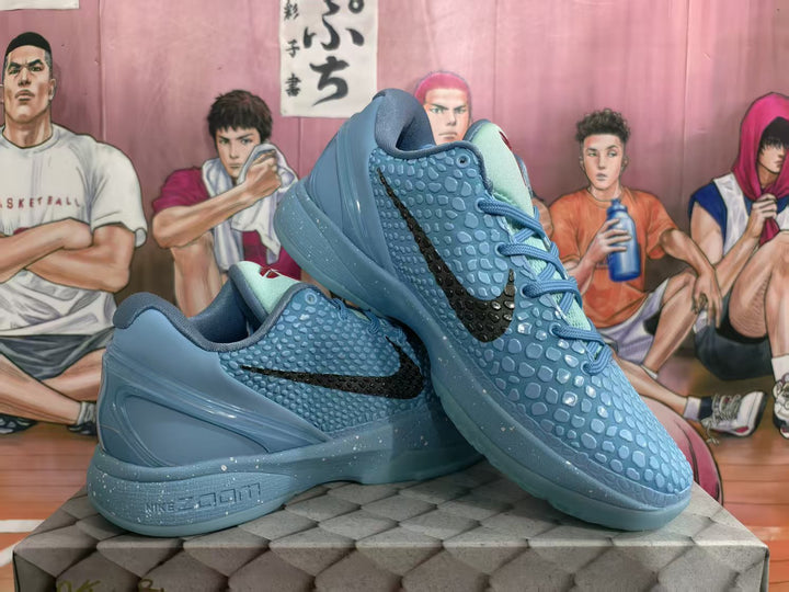 Pair of blue Nike basketball sneakers with textured uppers, black Swooshes, blue laces, and speckled midsoles.