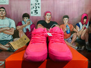 Front view of bright pink basketball sneakers with matching laces and textured toe areas.