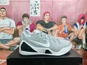 Side profile showing the white Swoosh, perforated gray upper, black side accents, and textured white outsole.
