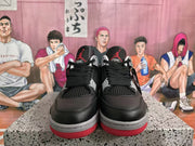 Front view of black and red high-top sneakers with black laces, grey eyelet accents, textured panels, and red outsole sections.