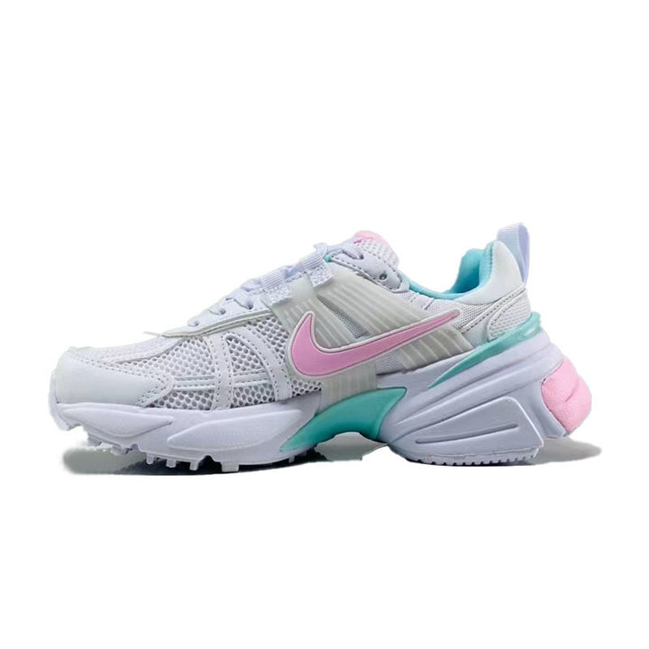 Side view of white Nike sneakers with a pink side logo, teal accents, mesh panels, and a chunky sculpted sole.