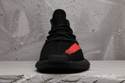 Front view of a black and red lace-up sneaker.