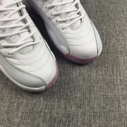 Close-up of the white textured toe boxes, stitching and pink outsoles.
