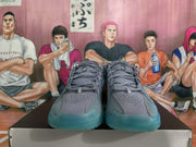 Front view of blue-gray Nike basketball shoes showing perforated uppers and teal-colored toe sections.