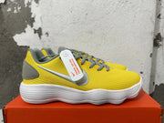 Side view showing yellow Nike sneakers with silver Swoosh details and gray trim