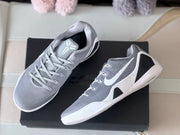 Pair of grey and white basketball shoes shown from above, including the tongue and side details.