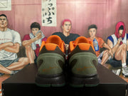 Rear view of orange basketball shoes with dark green heel panels and black midsoles