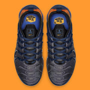 Top view of the pair showing navy laces, dark uppers, and orange heel lining.